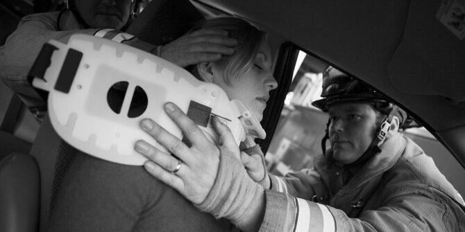 Firefighters helping an injured woman in a car