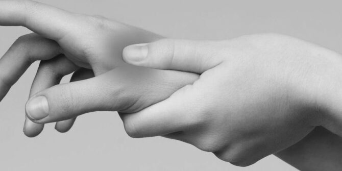 Hand clutching hand with red soreness indicator