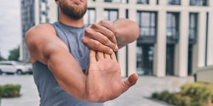 Man pulling back fingers to stretch wrist