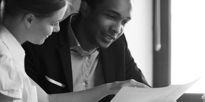 Seated female lawyer and male lawyer reading documents together