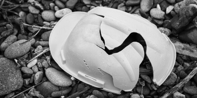 Cracked construction helmet resting on bedrock