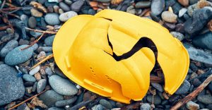 Cracked construction helmet resting on bedrock