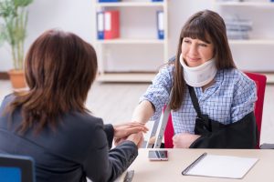 Woman in neck brace talking to workers compensation lawyer
