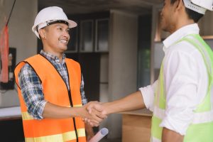 Two warehouse and construction workers shaking hands