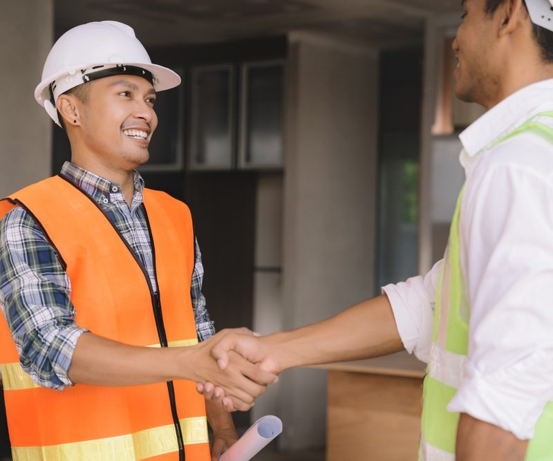 Two warehouse and construction workers shaking hands