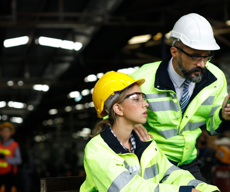 Male and female warehouse worker discussing workers comp