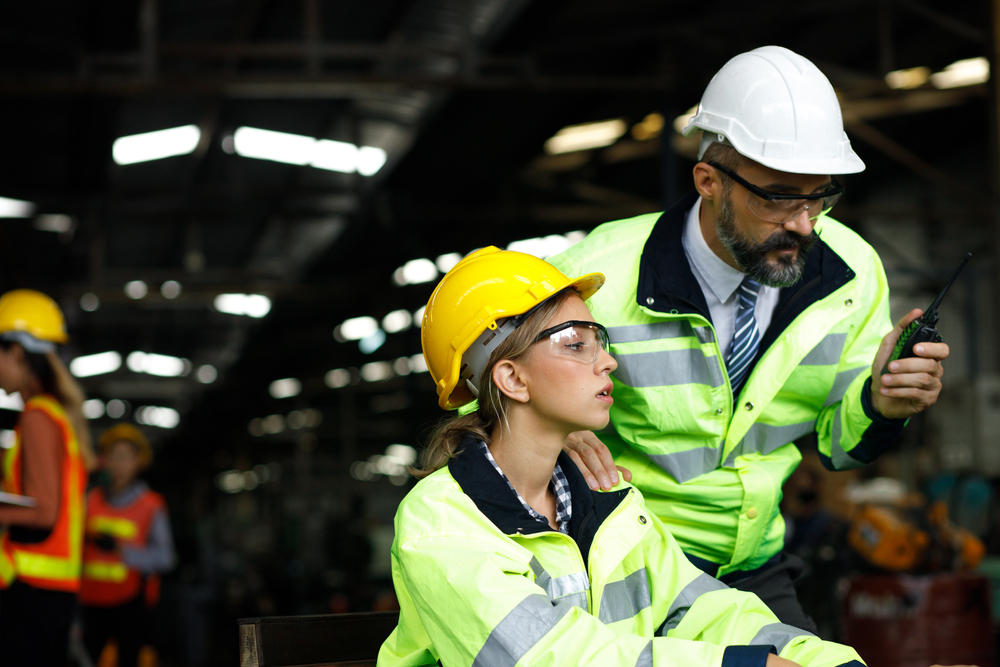 Male and female warehouse worker discussing workers comp