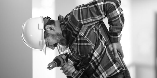 Warehouse worker injured on the job holding drill