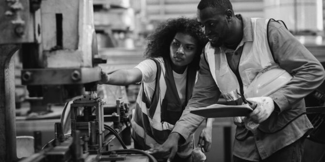 two warehouse employees inspecting a product