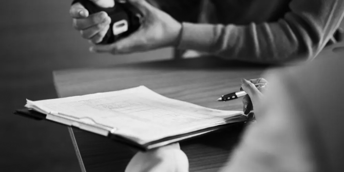 injured-employee-with-arm-in-cast-and-workers-comp-paperwork-on-desk